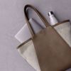 Shopper i brunt skinn og offwhite canvas. Bæres med to skulderhanker. Plass til 14" PC.