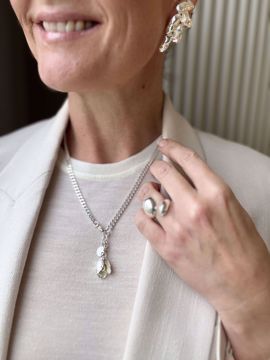 Charm og anheng i sølv formet som en epleblomstknopp. Inni de tre bladene skjuler det seg en gullkule. Charmen festes enkelt til smykker eller armbånd. 