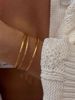 Gullbelagt Textured Armring brukt på håndleddet. 